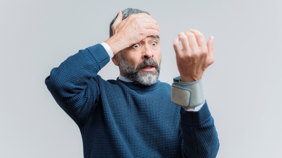 A man who is measuring his blood pressure and is shocked to see a reading of 130/80